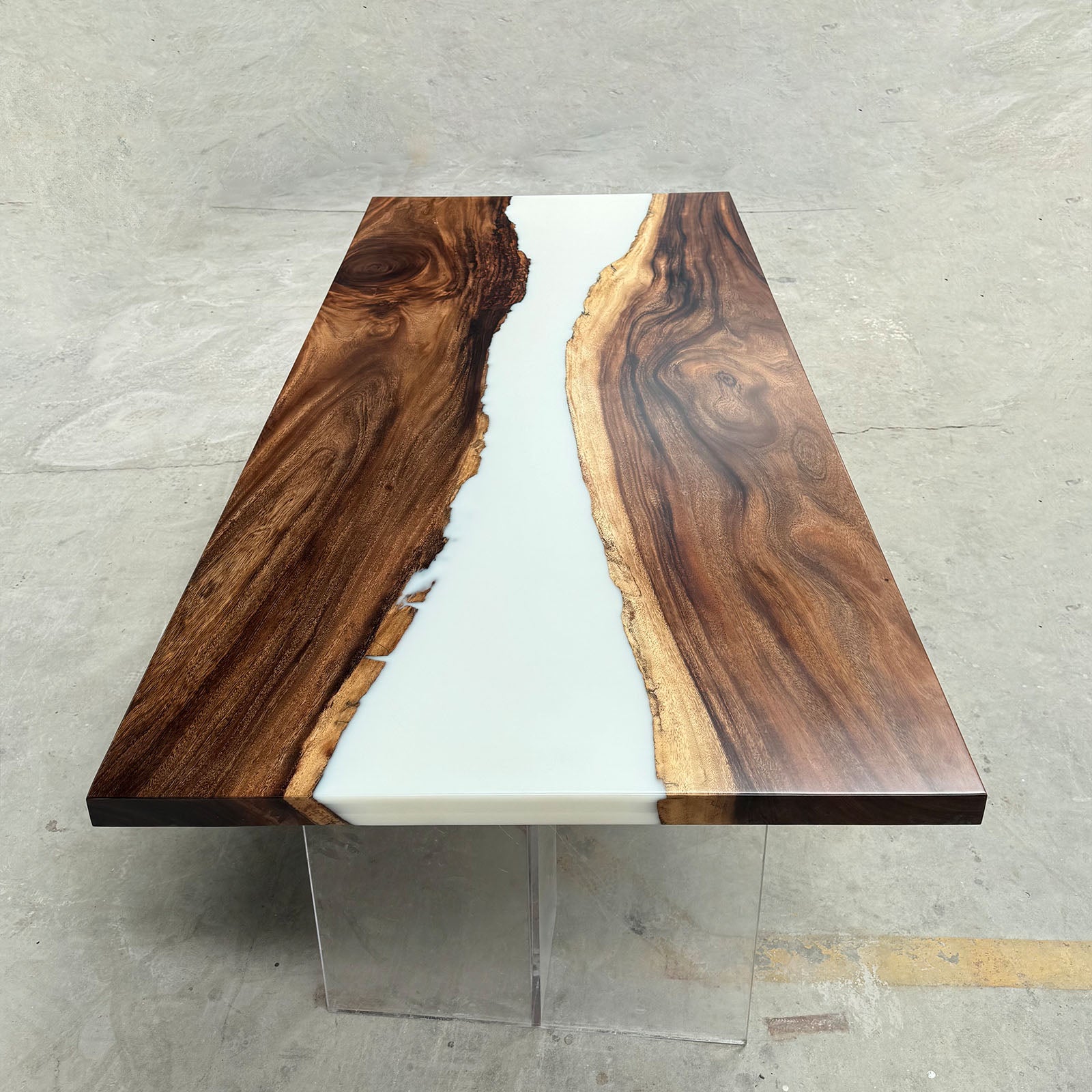 Side view of minimalist black walnut white epoxy table, elegant modern craftsmanship.