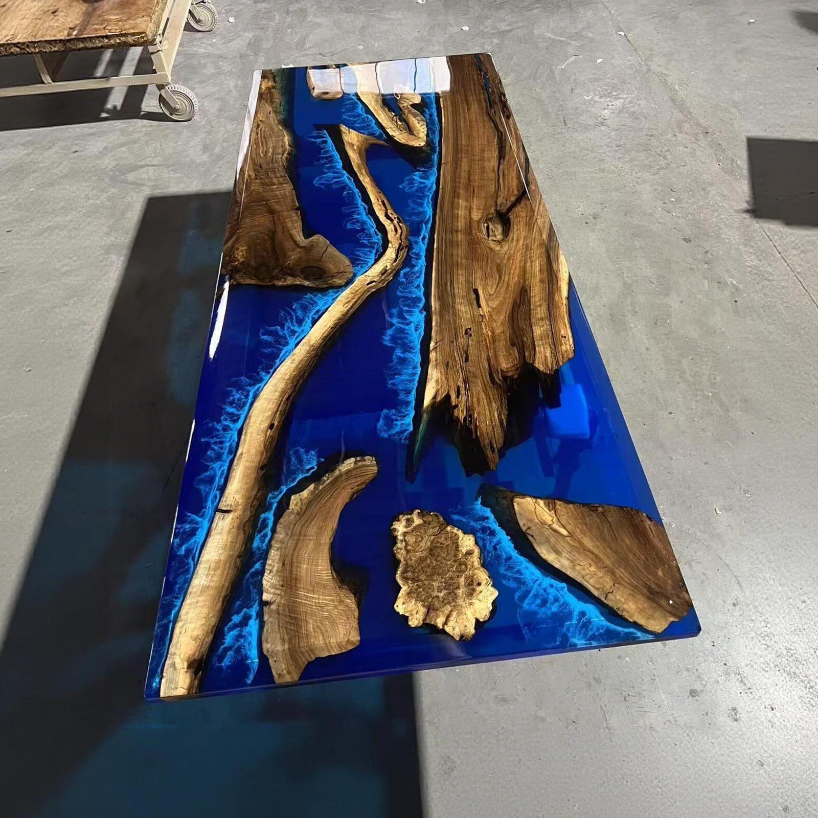 Black walnut table with ocean blue epoxy resin waves, beveled edge, and broken island design detail river dining table.