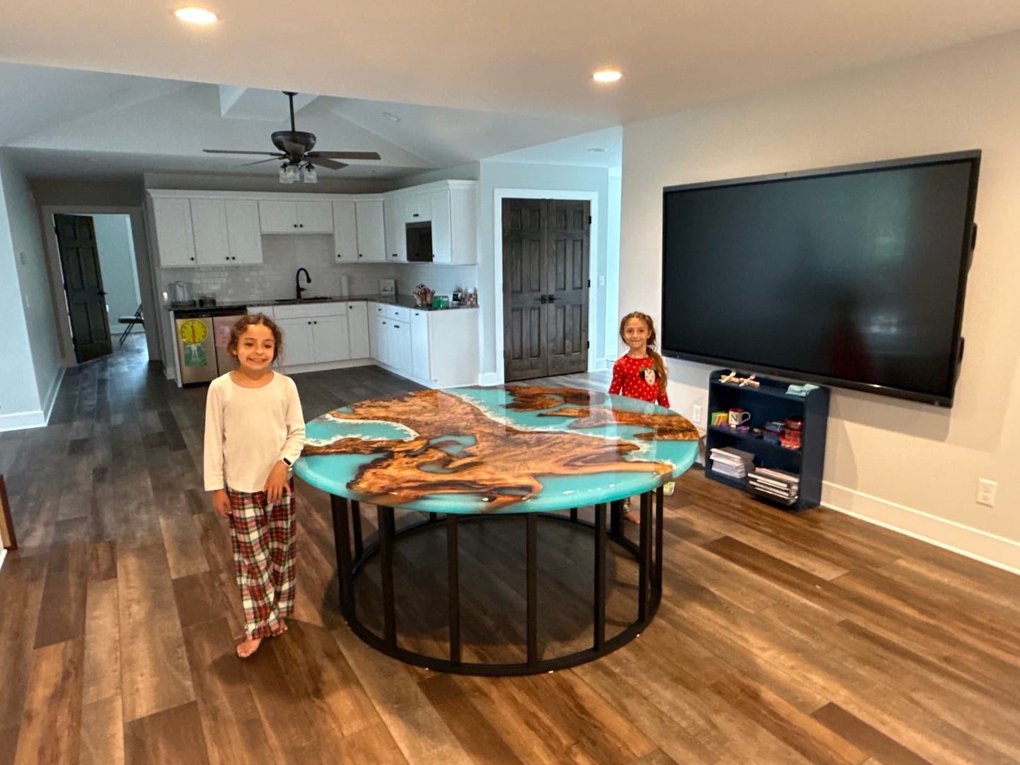 Custom round camphor wood and blue resin dining table installed in customer’s home