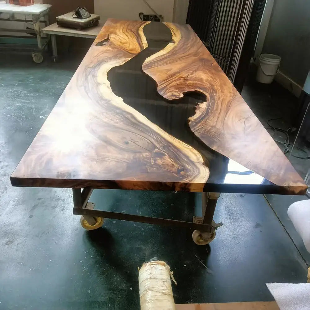 Walnut river table with translucent black resin during the curing process