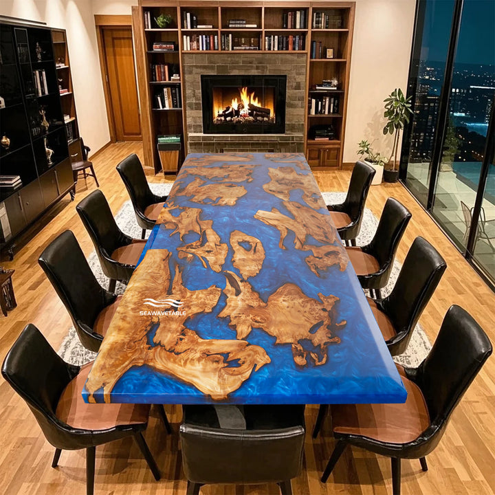 Modern dining room with a unique blue and wood-patterned table and black chairs.