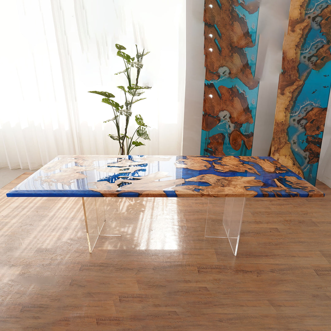 Modern dining table with blue and brown design in a room with a plant and abstract wall art.