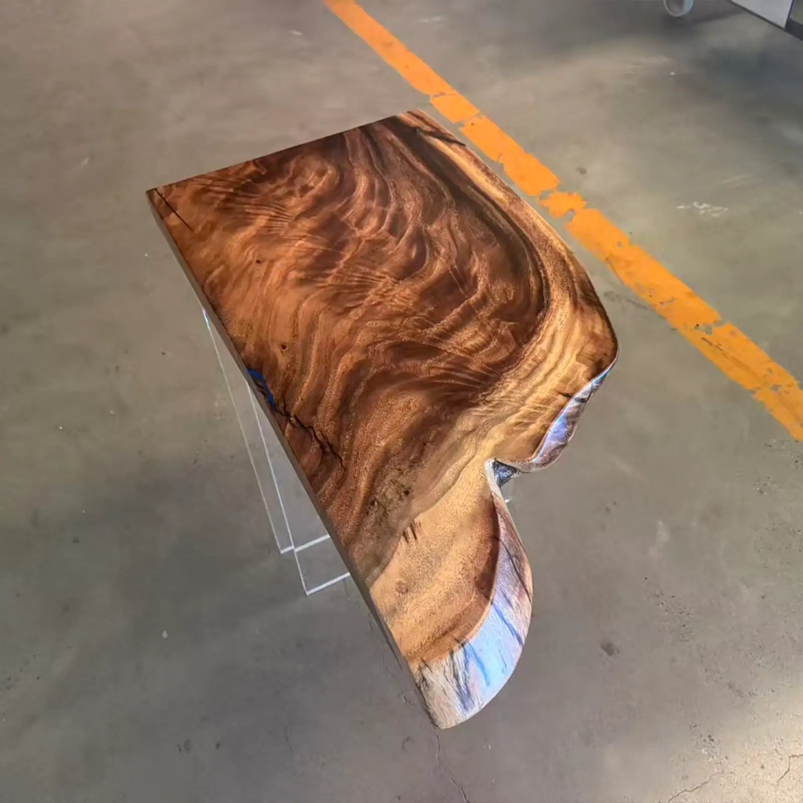 Wooden coffee table with a natural grain pattern on a concrete floor.