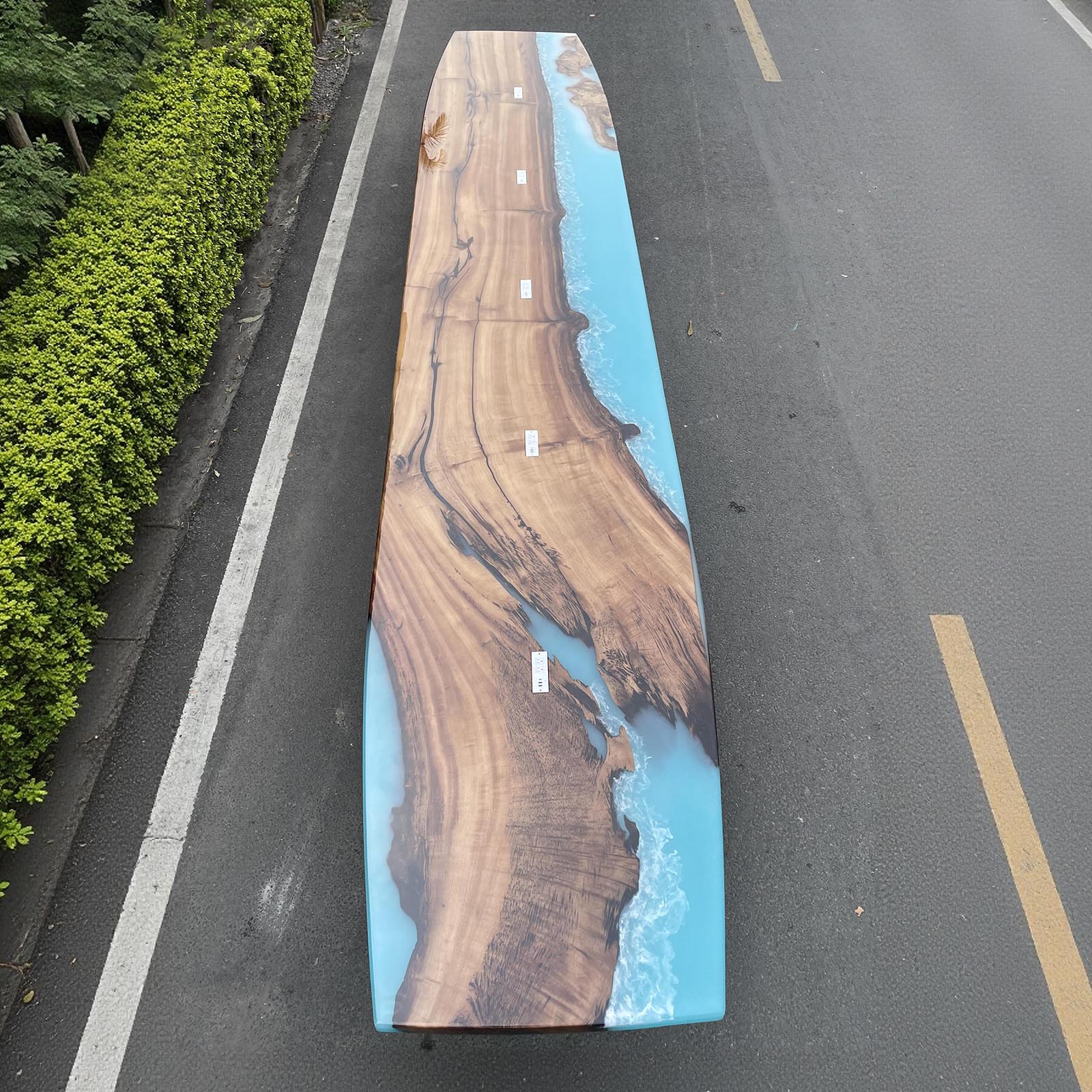 Top view showing artistic ocean wave resin patterns on golden camphor wood surface.