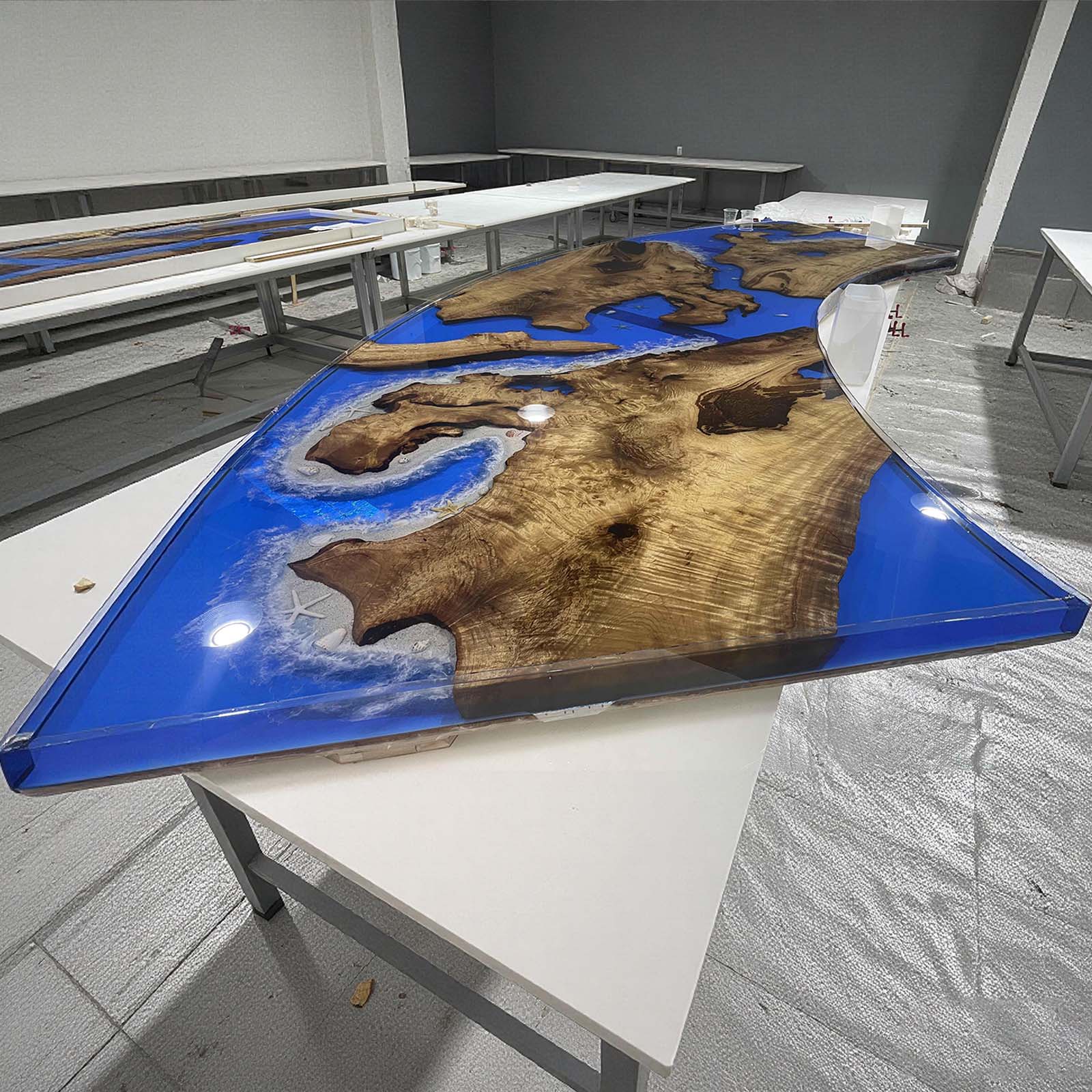 Ocean-inspired golden camphor resin table under natural light, emphasizing clarity of blue epoxy river.