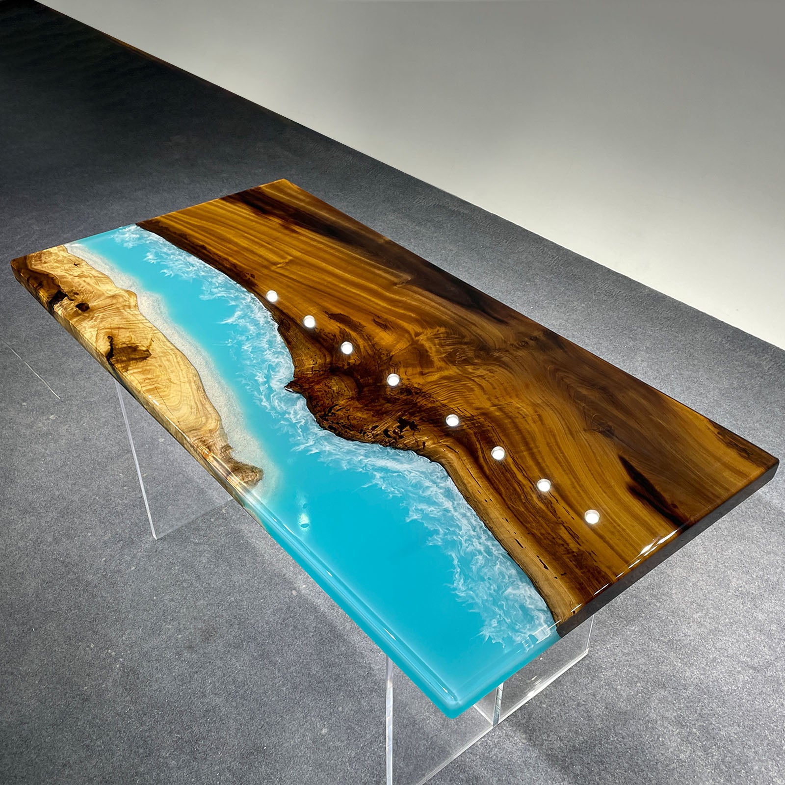 Detailed view showing the contrast between natural golden camphor grain and ocean blue epoxy resin.