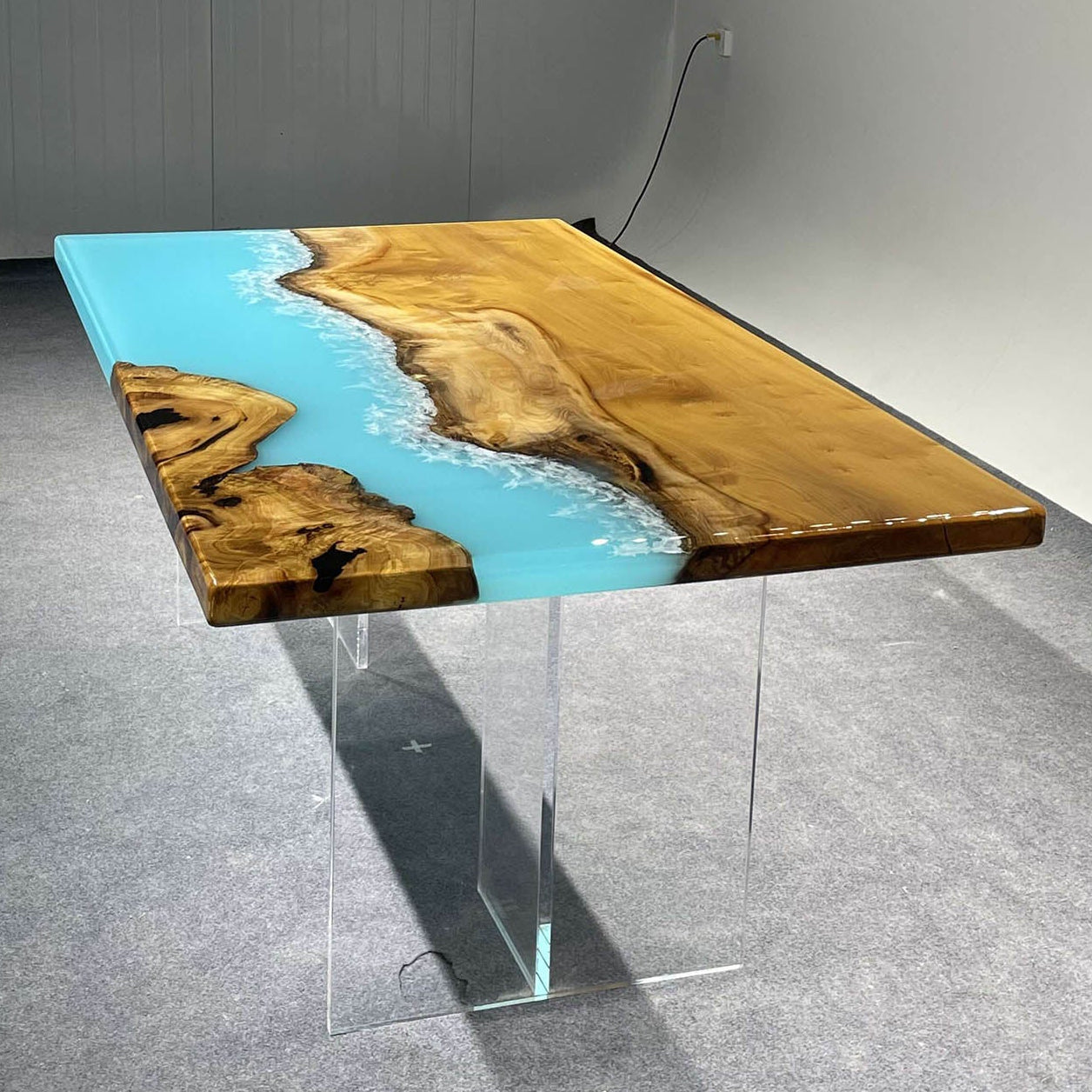 Side view of golden camphor wood epoxy table with soft ocean wave pattern and natural wood finish.