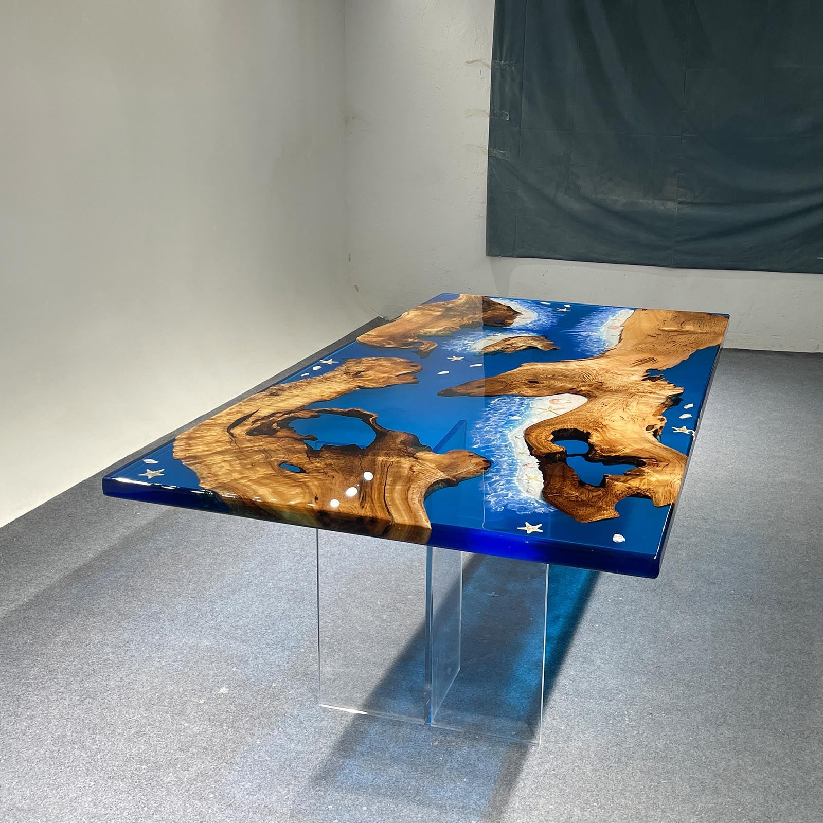 Artisan detail of a golden camphor wood table featuring clear blue resin, natural white sand, and ocean-inspired inlays in Lewisberry, PA