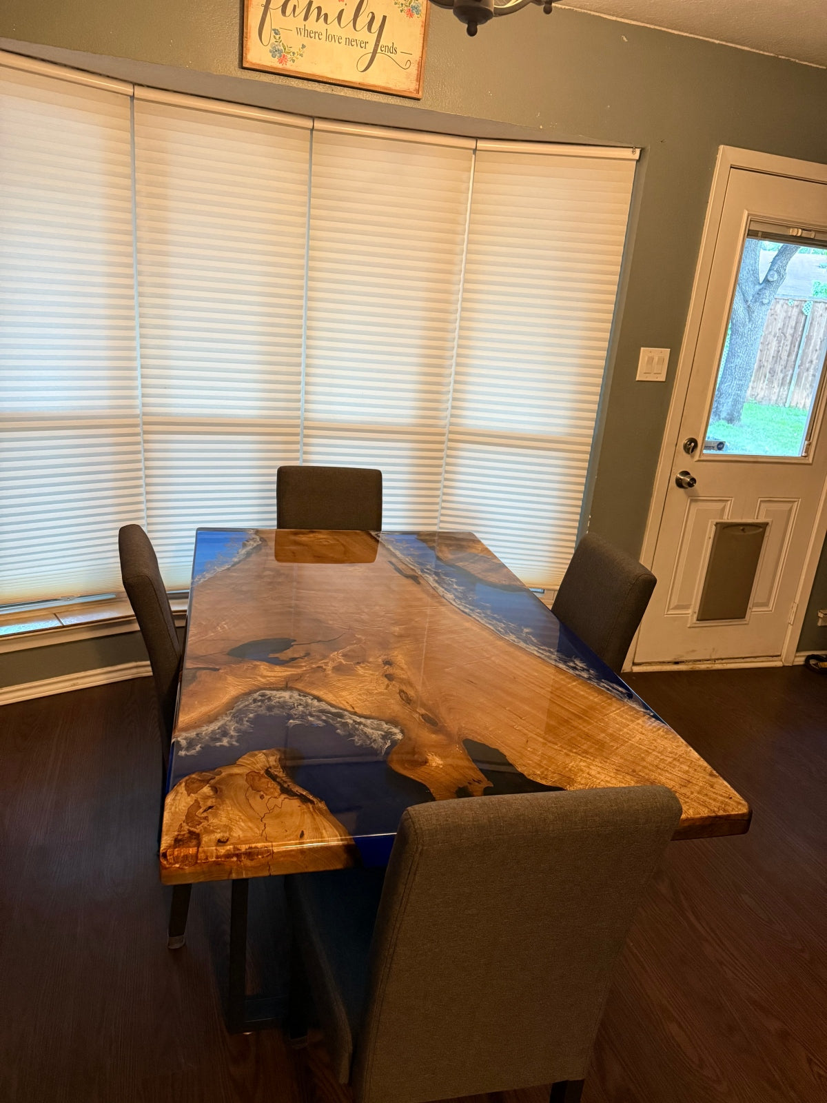 Straight-edge detail of a golden camphor epoxy table, featuring transparent blue resin and a sleek high-gloss finish for a modern coastal look.
