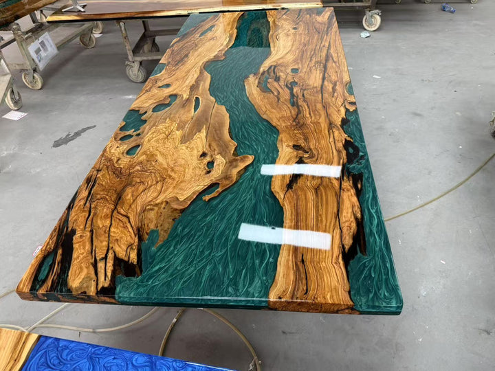 olive wood slab table with green resin inlay on a concrete floor