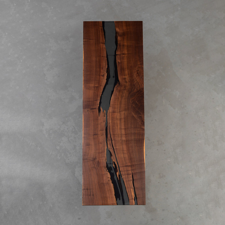Handcrafted black walnut executive meeting table with translucent black resin and straight edges.