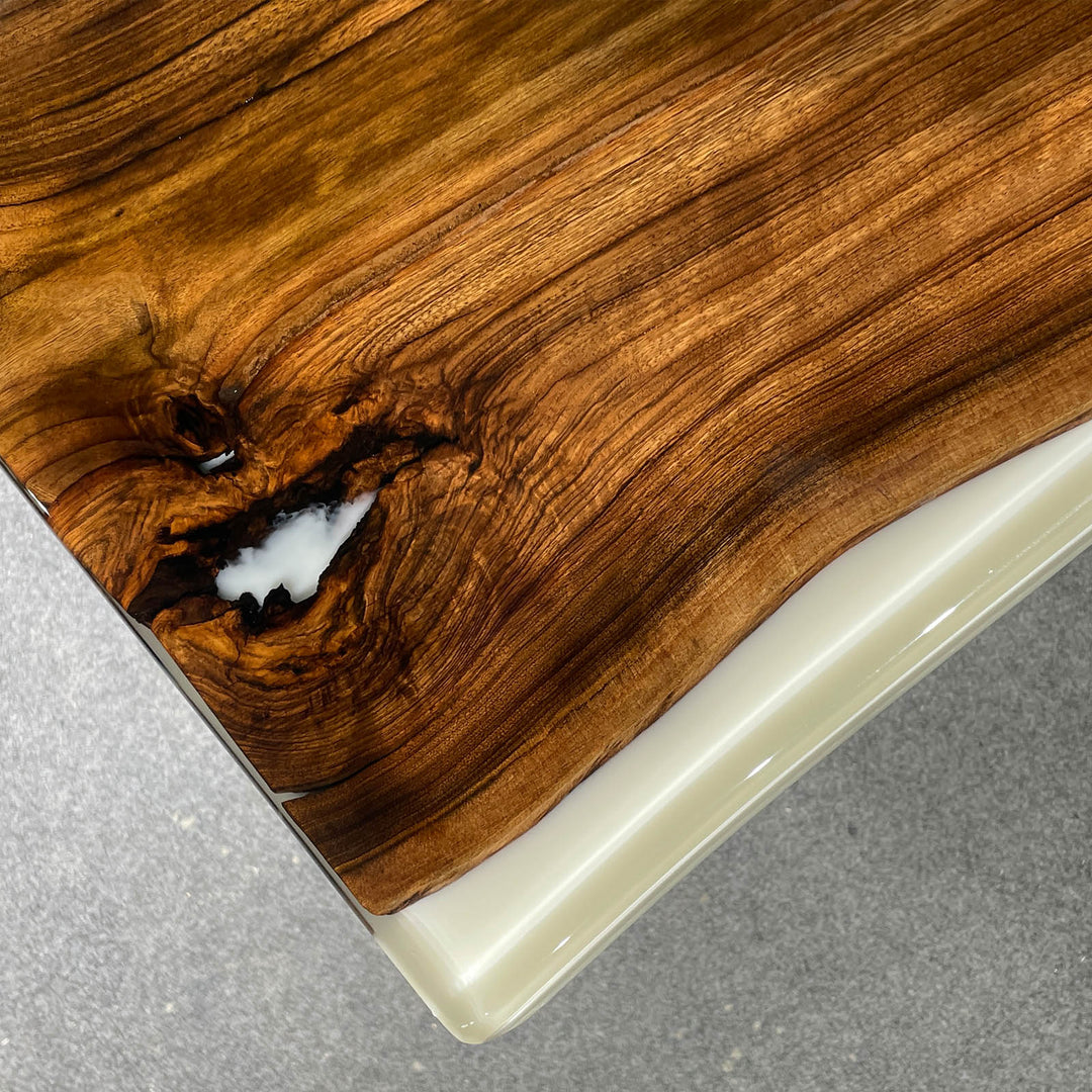 Wooden cutting board with a white edge on a gray surface