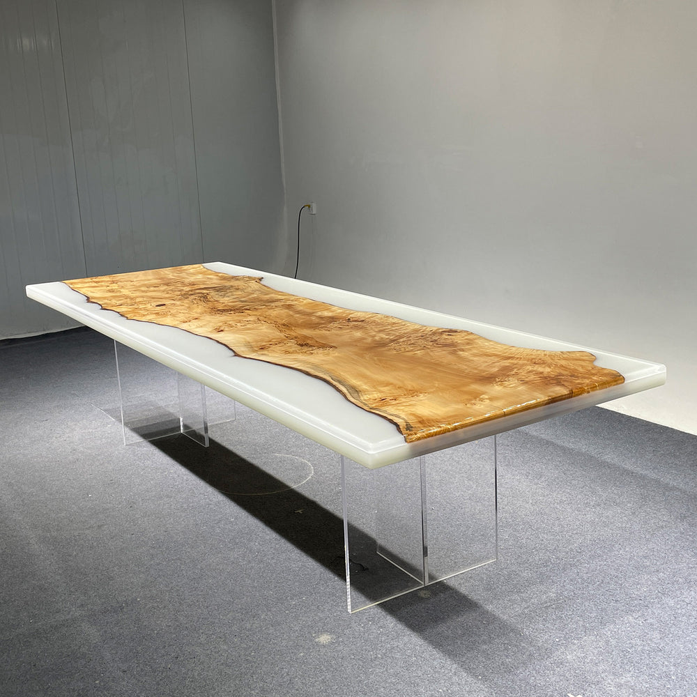 Modern dining table with wooden top and clear acrylic legs on a gray floor.