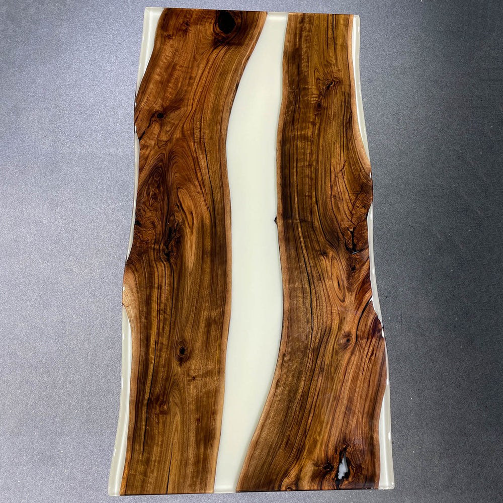 Wooden slab with a white resin inlay on a gray background