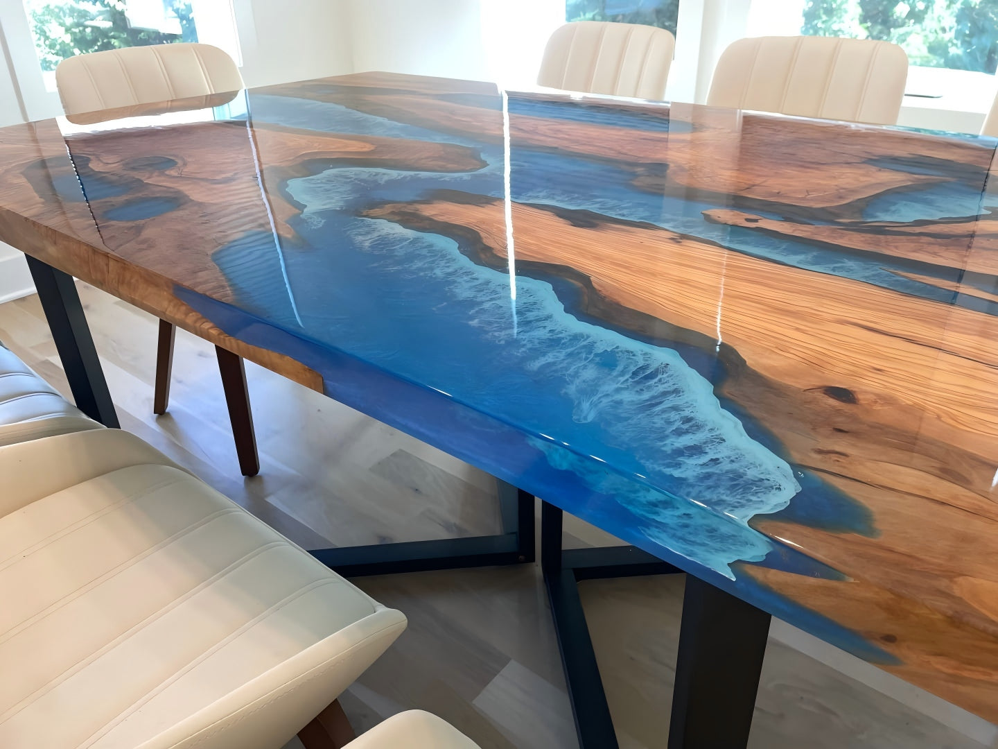 Live edge olive wood table featuring deep ocean blue epoxy river design