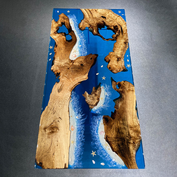 Wooden art piece with blue resin and star patterns on a gray background