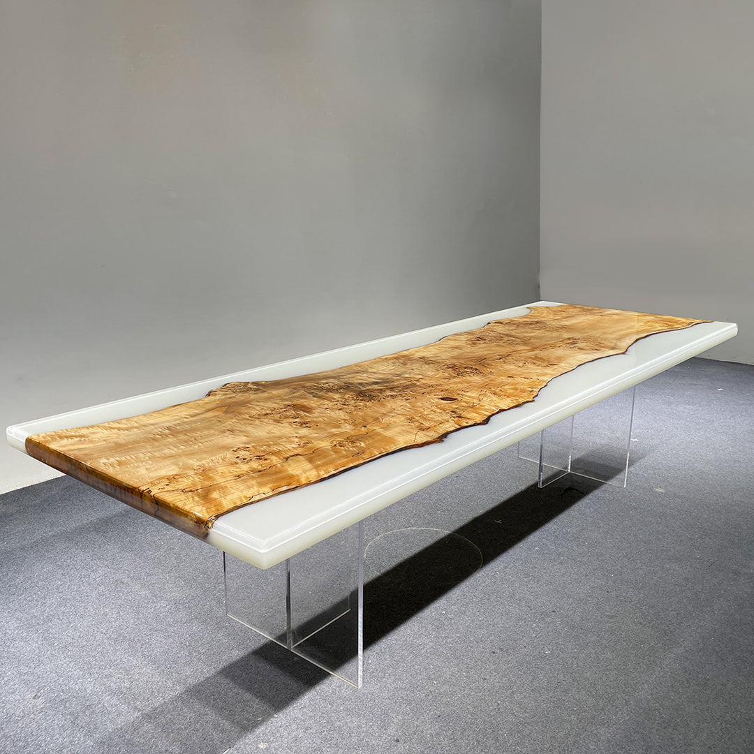 Long wooden bench with white base and clear legs on a gray floor.