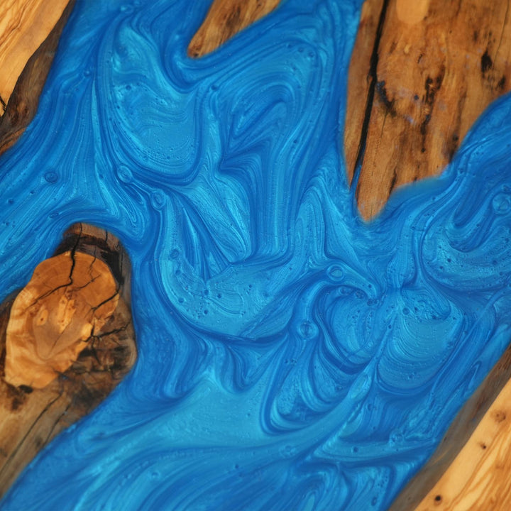 Luxury open-concept interior featuring custom blue epoxy river dining table with olive wood