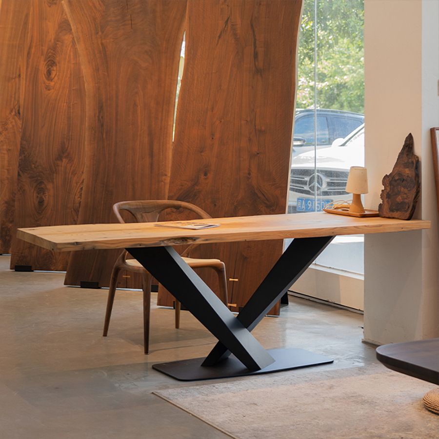 MTL17 sculptural X-shaped black metal table base supporting a custom walnut dining table in a modern interior