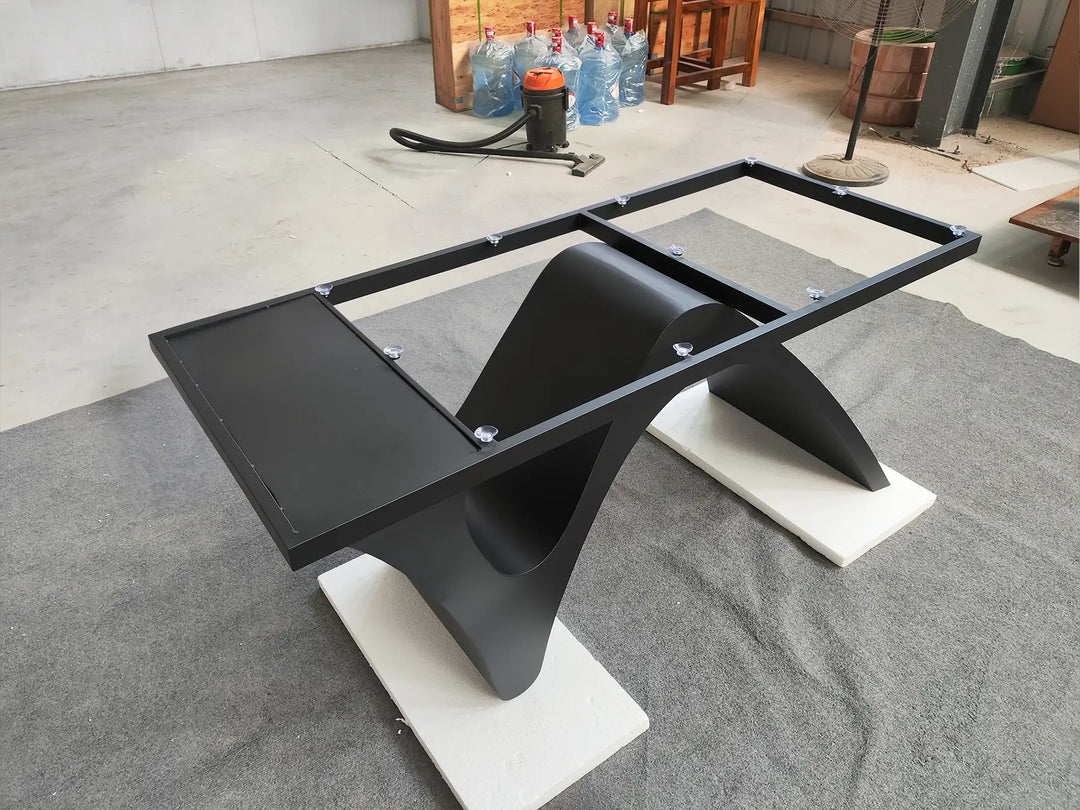 Angled side view of the MTL20 curved X-shaped metal table base showing its sculptural support structure