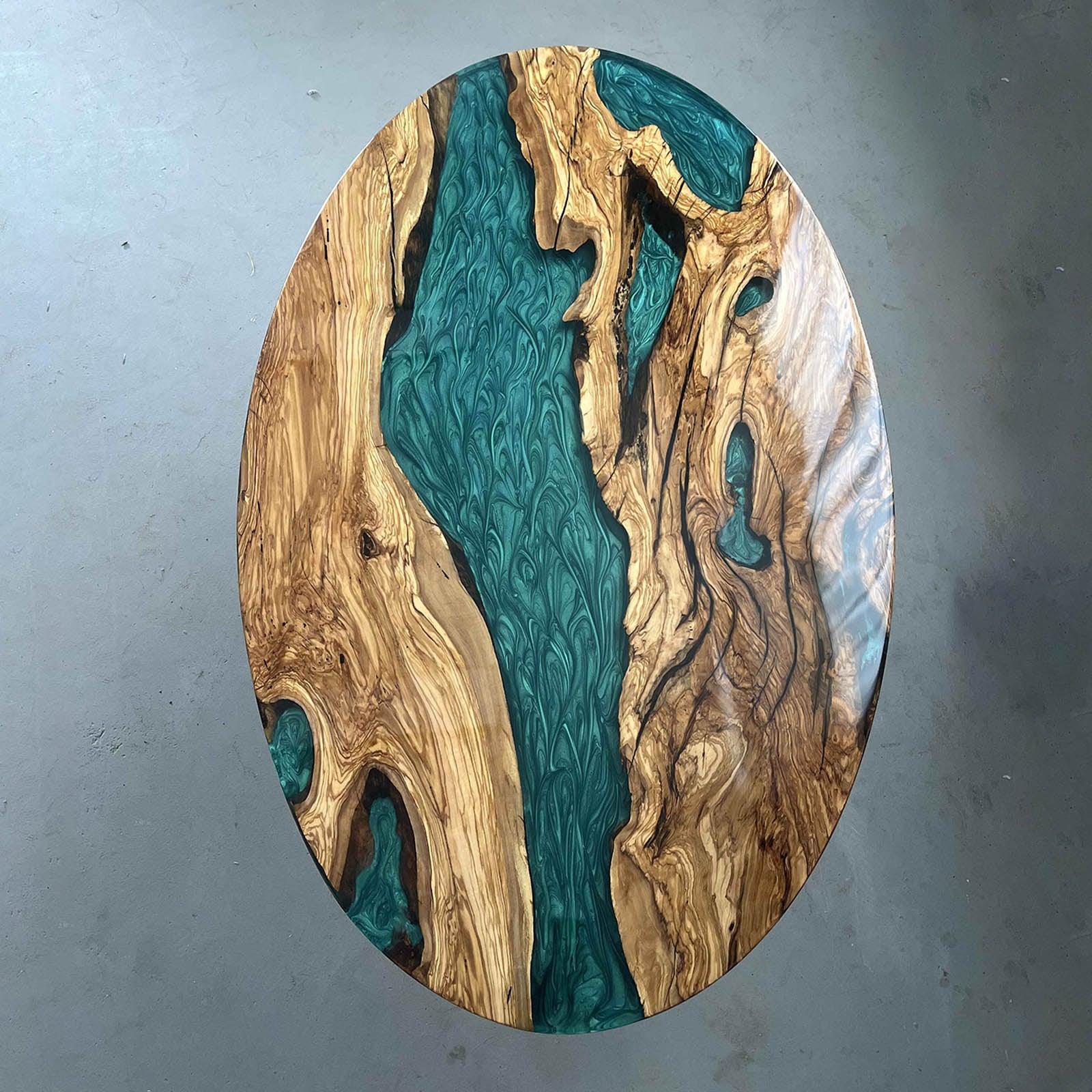 Olive wood dining table with Mystic Lagoon epoxy resin, perfect for luxury modern interiors.