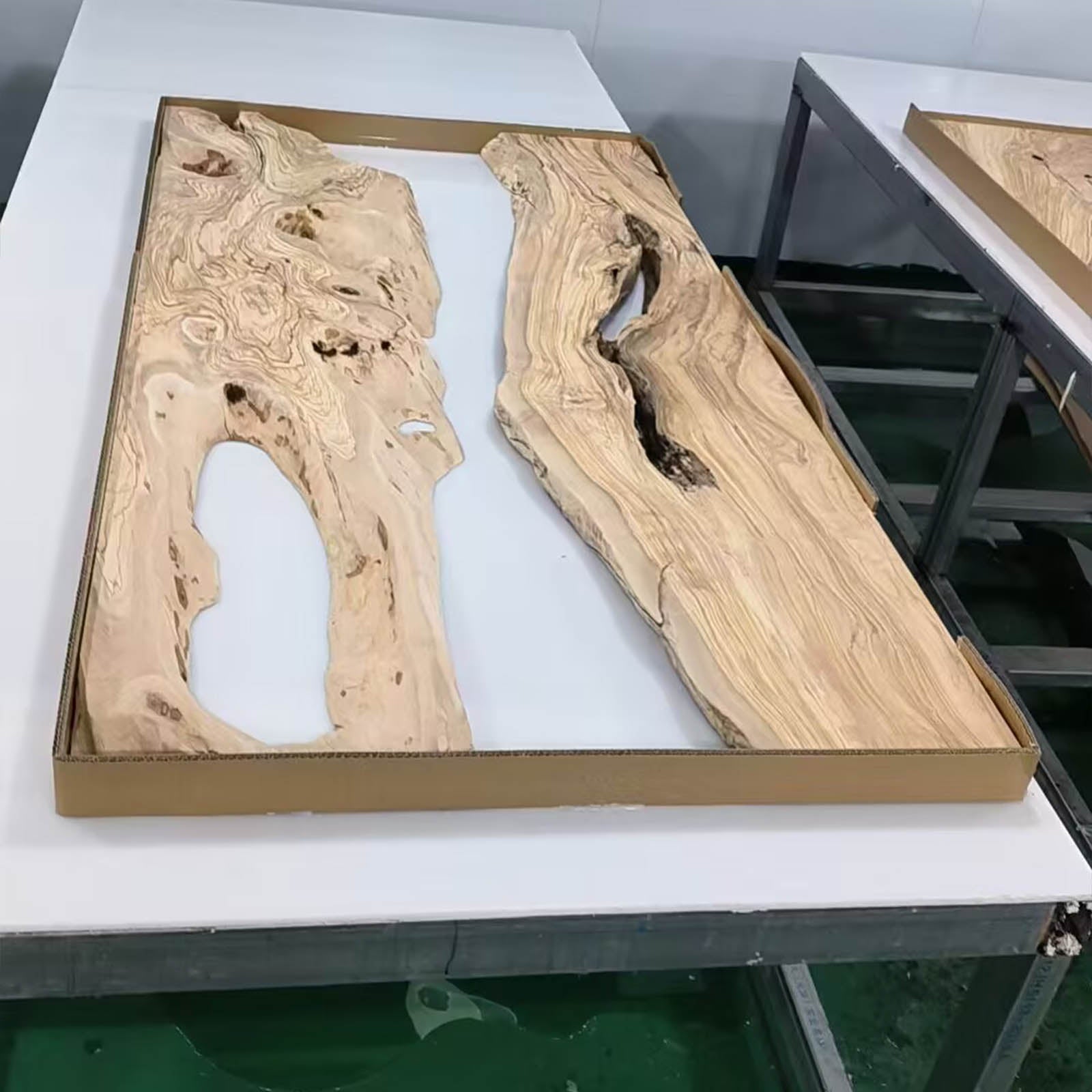 Close-up of blue-green epoxy river flowing between olive wood slabs, showing detailed resin pattern.