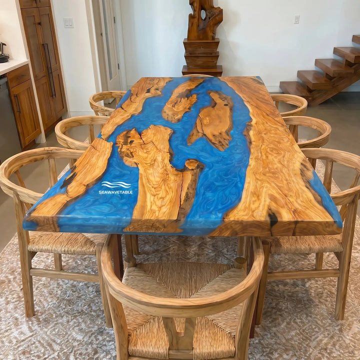 Front view of custom olive wood epoxy river dining table with blue resin and straight edge design in Malibu style