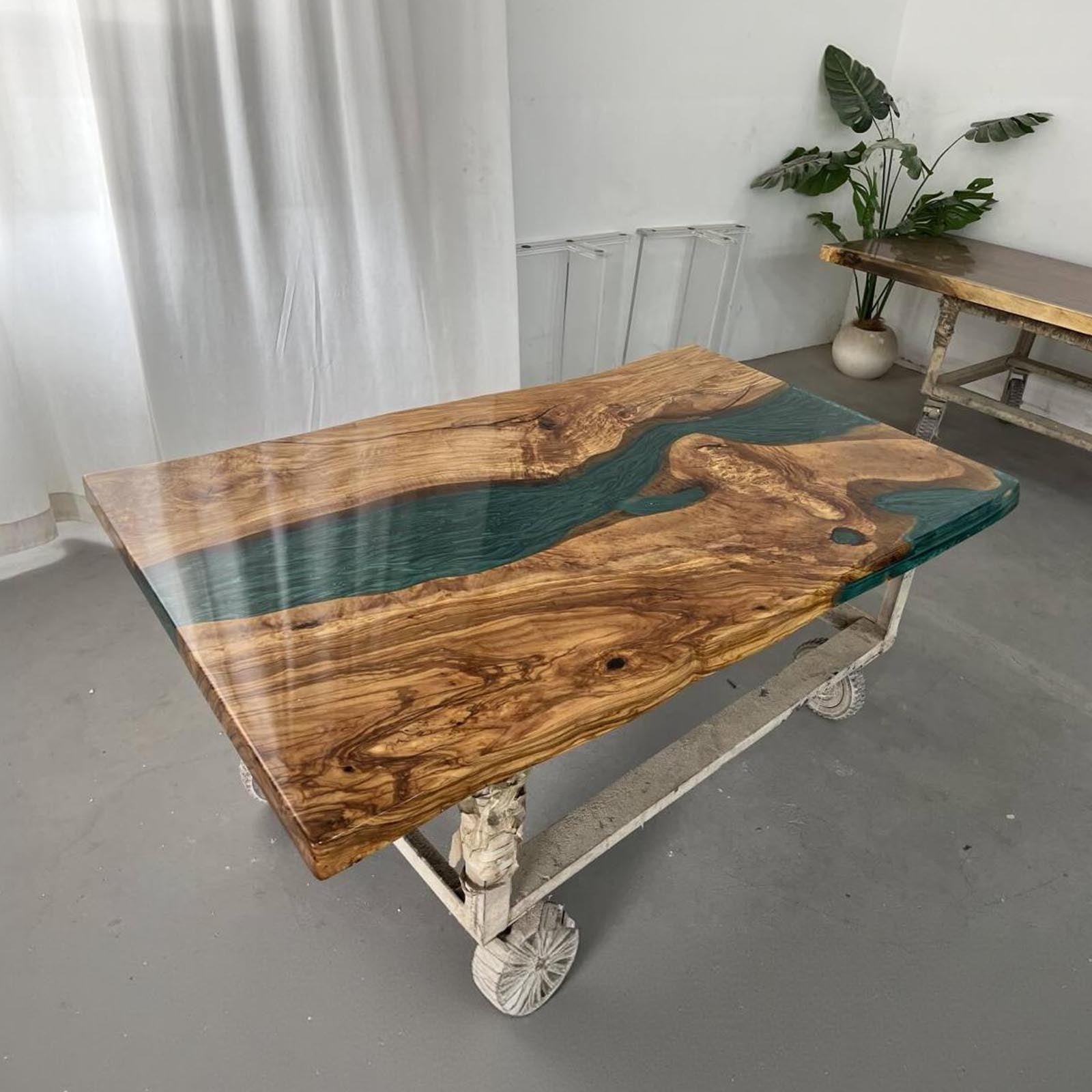 Large olive wood dining table with Mystic Lagoon epoxy river centerpiece, luxury dining room design.