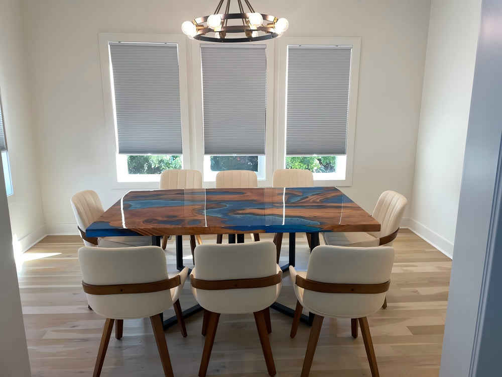 Close-up of olive wood epoxy table with swirling ocean blue resin and rich wood grain