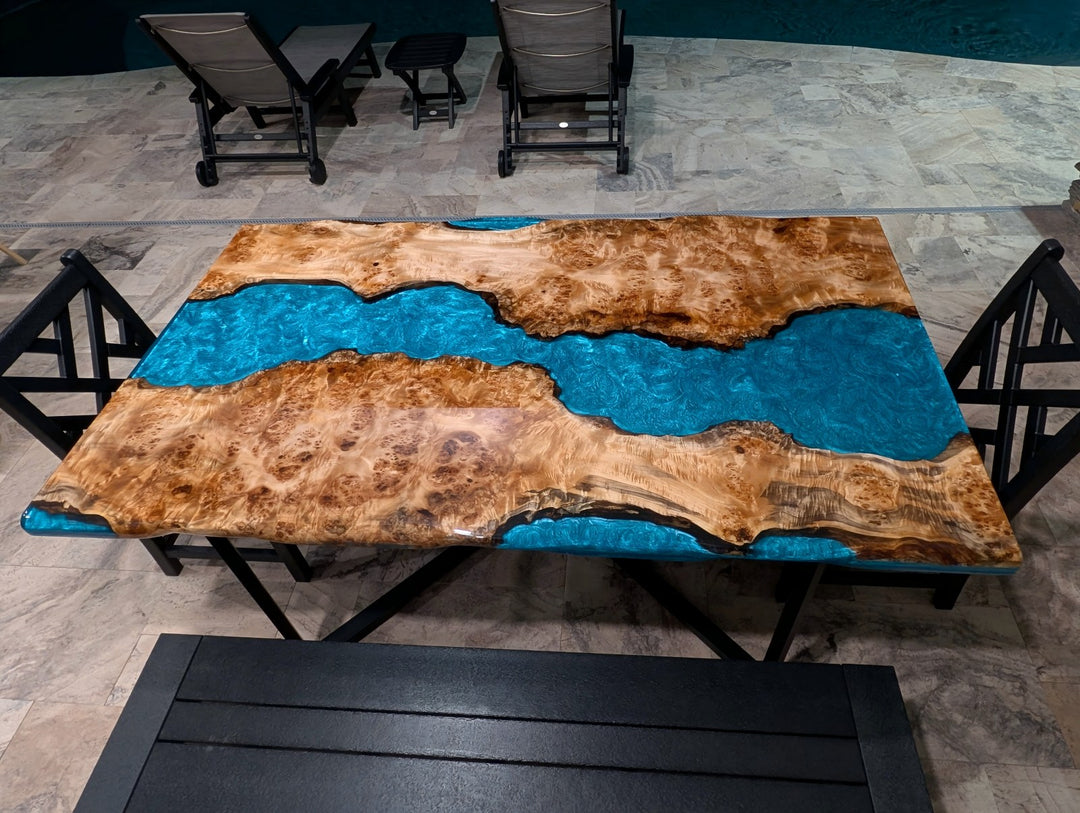 Poplar and blue epoxy table placed inside outdoor pavilion.
