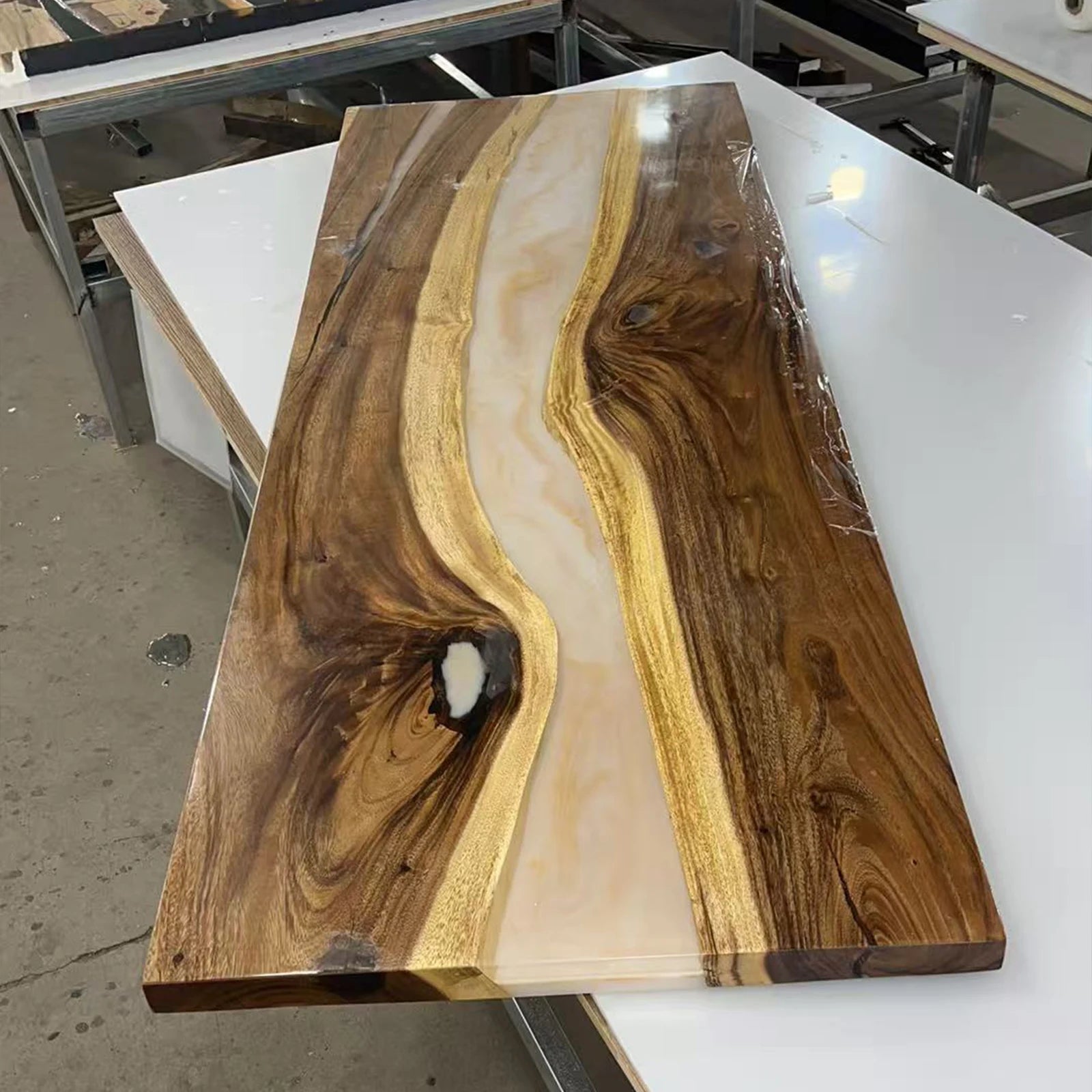 SeawaveTable craftsmen pouring resin into a walnut slab during the custom table making process