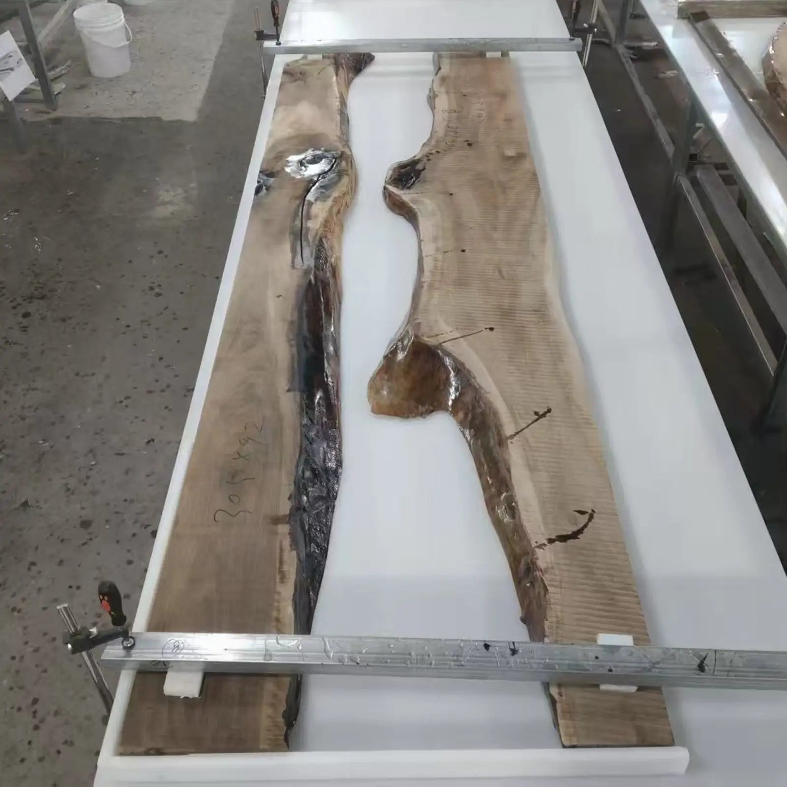 SeawaveTable black epoxy pouring process for custom river conference table with deep resin design