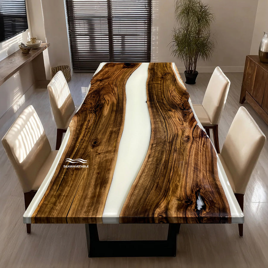 Dining table with wooden surface and white resin inlay, surrounded by chairs in a room.