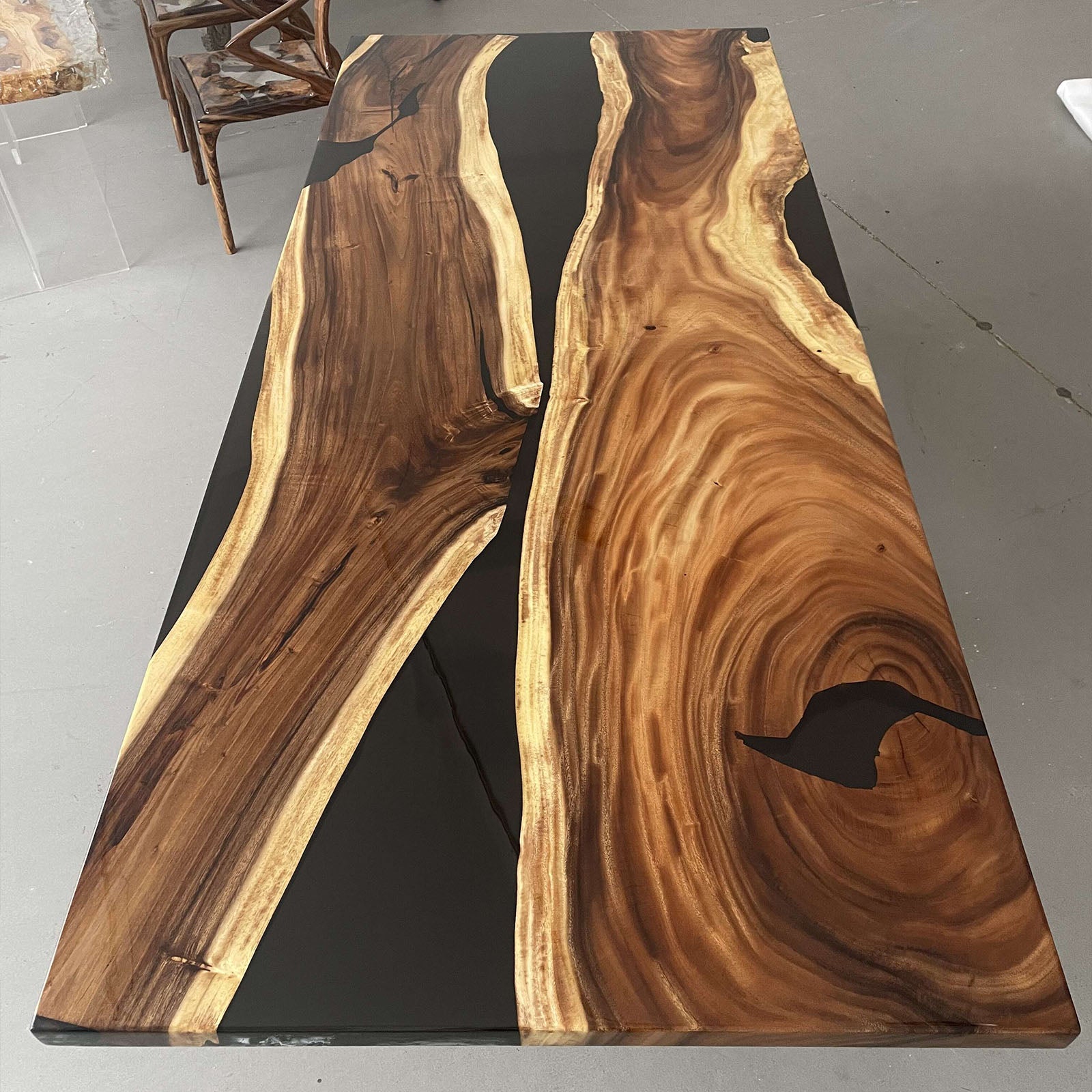 Solid walnut meeting table with straight edges and a polished black epoxy river centerpiece.