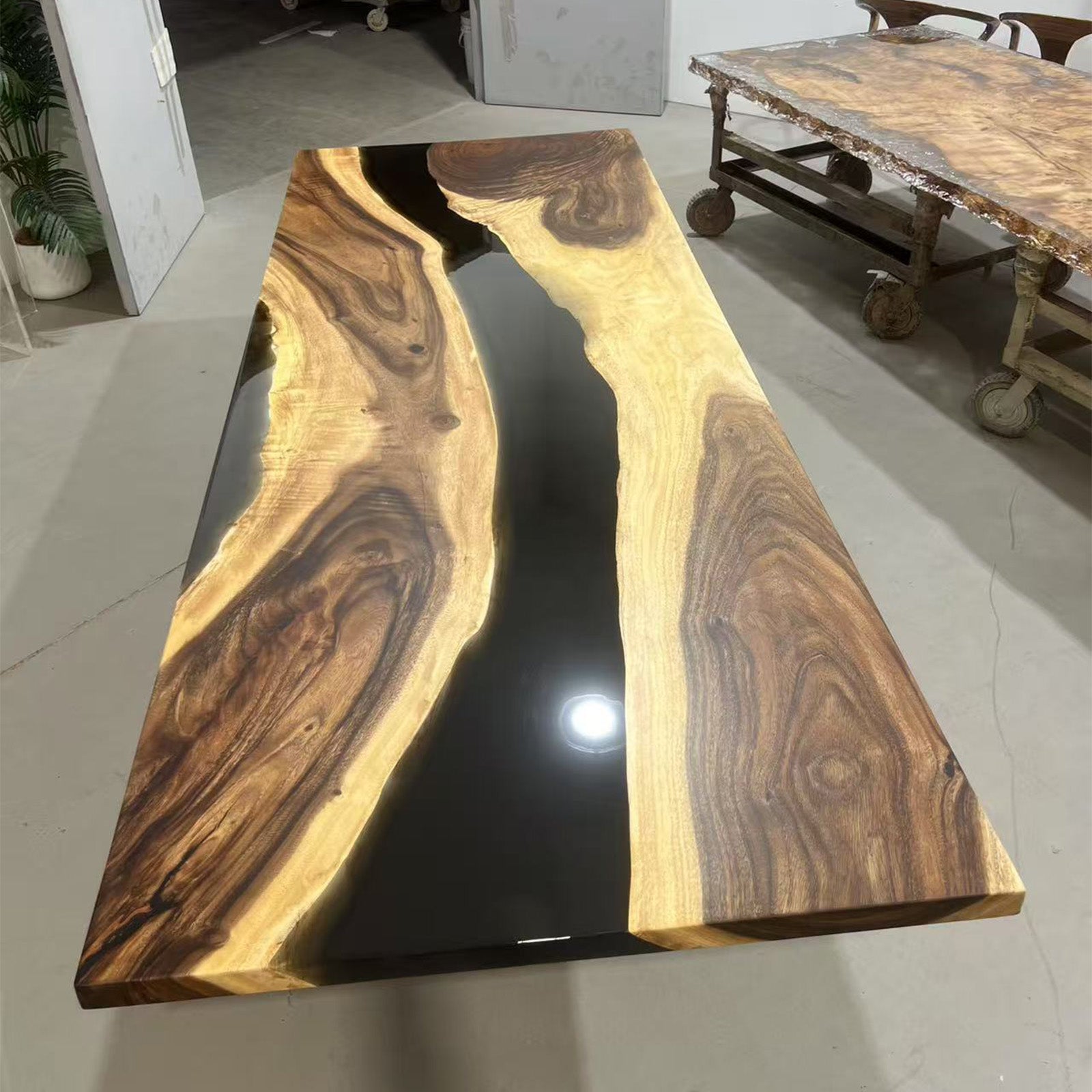 Handcrafted live edge walnut dining table with white sapwood highlights and black epoxy river.