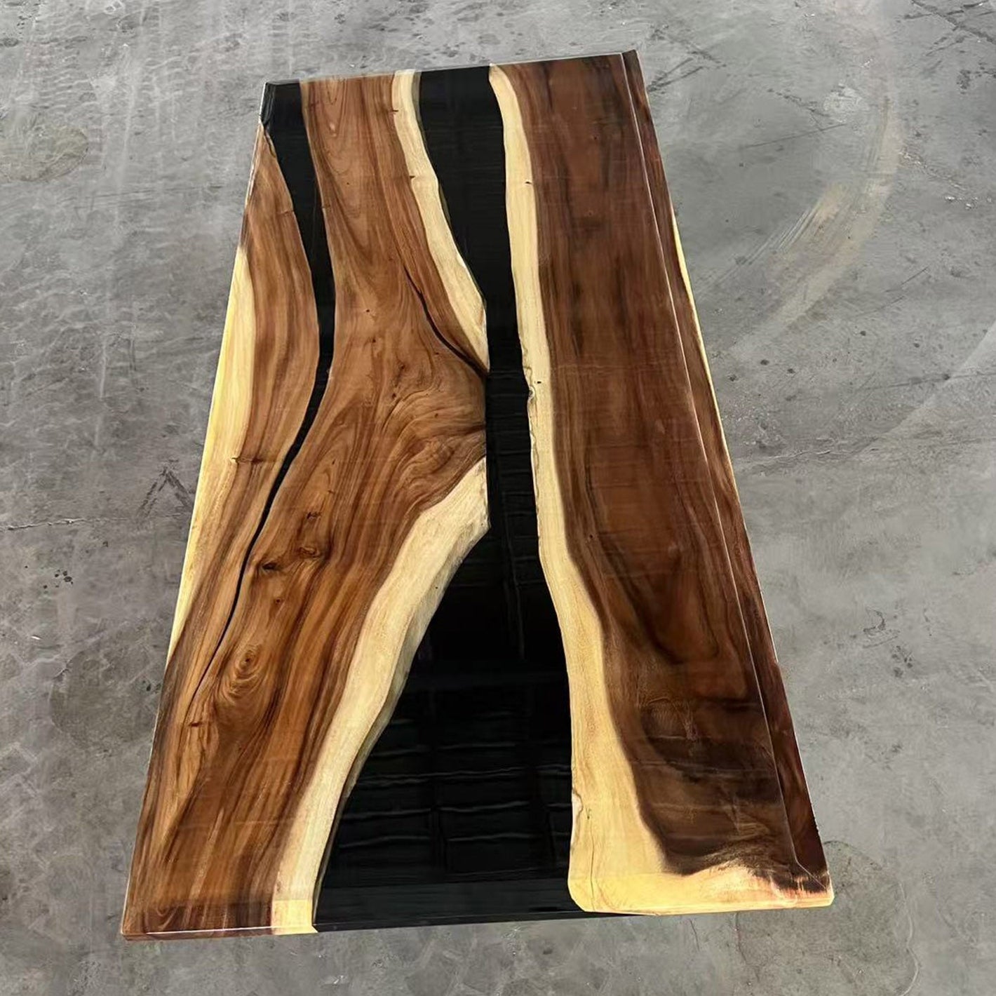 Walnut river table with white sapwood accents and black epoxy, styled for minimalist interiors.